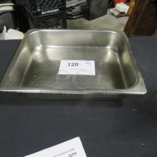 Stainless steel half-size hotel pan, 2.5 inches deep, lightly used condition with surface scratches. Auction tag "120" visible inside.