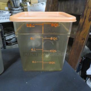 Transparent 8-quart food storage container with orange lid, featuring measurement markings in quarts and liters.