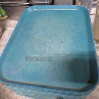 Stack of 25 blue 18x14 lunch trays with visible scratches, indicating use. Suitable for cafeteria or catering settings.