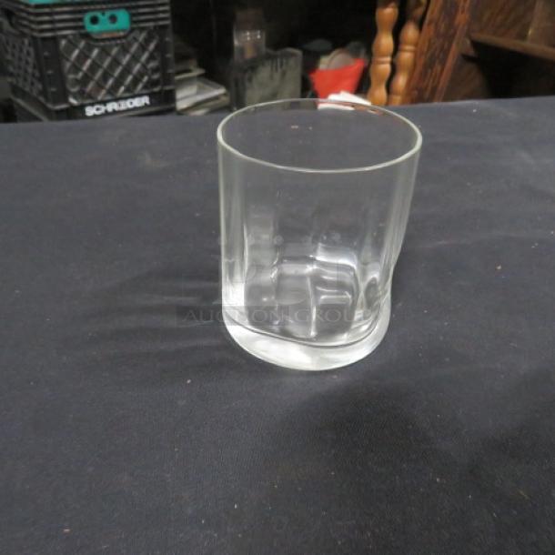 Clear glass rocks glass, model 9XBID, in good condition with a textured base, displayed against a dark background.