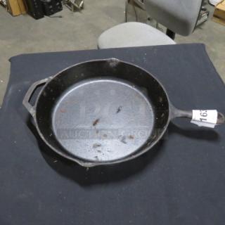 12-inch cast iron skillet with side handle, showing signs of use. Moderate wear, suitable for cooking or collection. No visible brand.