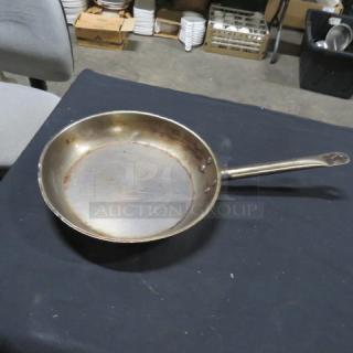 12-inch sauté pan with long handle, 3XBID, metallic finish, showing signs of use, minor scratches on cooking surface.