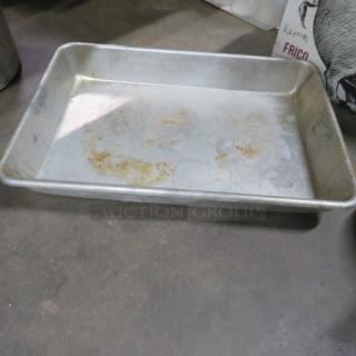 Aluminum roasting pan with visible wear and discoloration, rectangular shape, suitable for large roasts or casseroles.