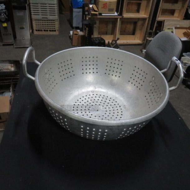 16-inch aluminum colander with perforated design and side handles, shown in used condition.
