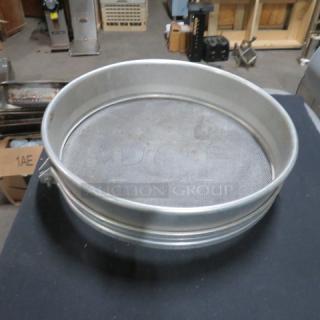 17-inch metal sifter, circular design, fine mesh screen, good condition, suitable for kitchen or industrial use.