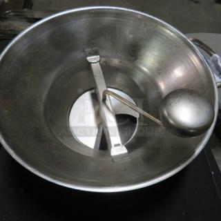 Metal food mill with attached crank and blade, used condition. Suitable for pureeing foods, essential kitchen tool.