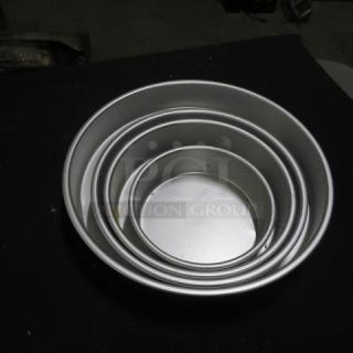 Set of four nesting round baking pans, appear new, silver metal, stacked. Ideal for baking enthusiasts.