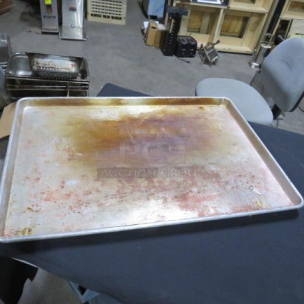 One full-size sheet pan with visible wear and discoloration, suitable for commercial baking needs.
