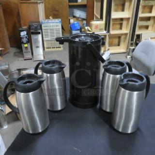 Assorted beverage dispensers without lids; includes one tall black dispenser and four stainless steel dispensers. Used condition.