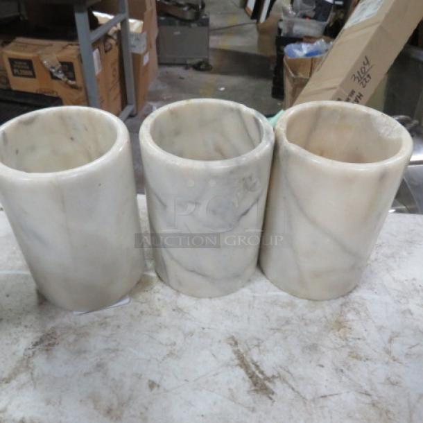 Set of three heavy marble wine bottle holders with natural veining, good condition.