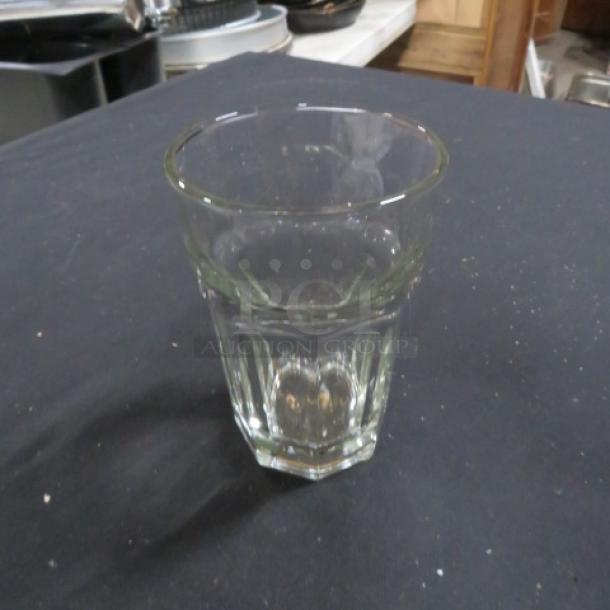 Clear cocktail/bar glass, 10XBID model, in good condition. Simple design with a slightly tapered shape, on a dark surface.