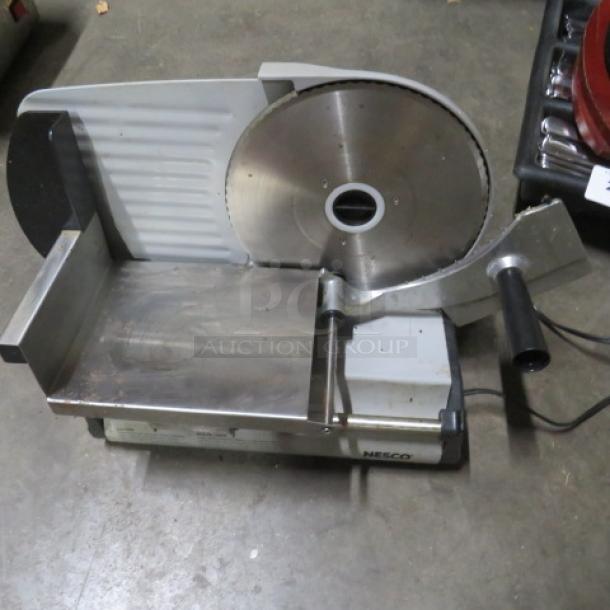 Nesco FS-250 Deli Slicer in used condition. Features stainless steel blade, sturdy base, and visible brand marking.