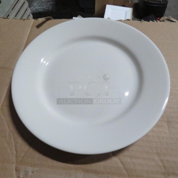 White 9.5-inch plate, new condition, classic round design, sits on a cardboard surface. Suitable for dining or display.