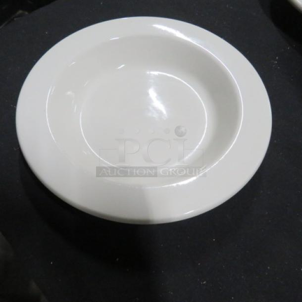 White 9.5-inch ceramic bowl on a black surface, in excellent condition. Simple, smooth design with a glossy finish.