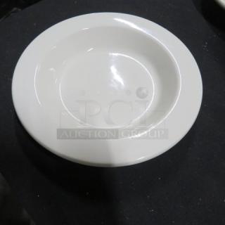 White 9.5-inch ceramic bowl on a black surface, in excellent condition. Simple, smooth design with a glossy finish.