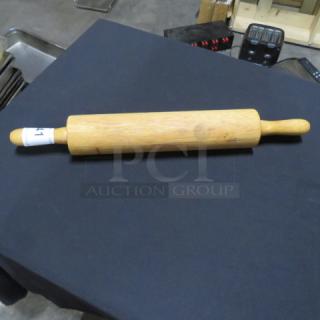 Wooden rolling pin with smooth finish and two handles, minor wear visible, auction tag attached to one handle.