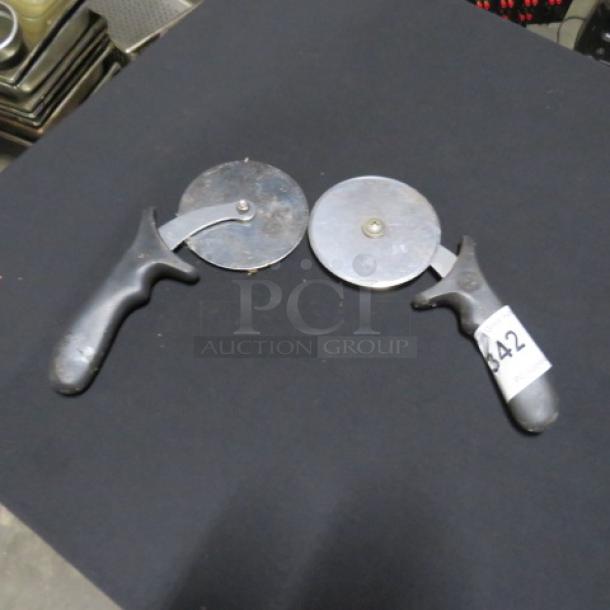 Two metal pizza cutters with black plastic handles, marked "2XBID," handle tagged "342." Good condition.