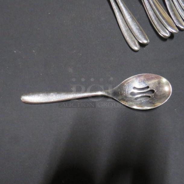 Lot of 14 silver-toned slotted spoons, stainless steel, lightly used, ideal for serving, clean design.