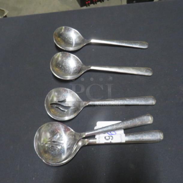 Lot of 6 slotted silver serving spoons; used condition with visible slotted designs; metal finish shows light wear.