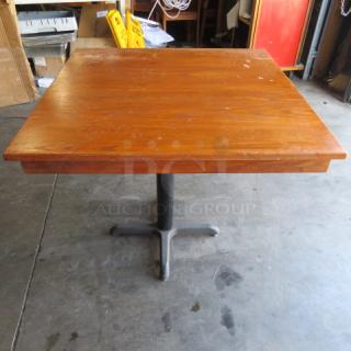 Wooden table top with pedestal base, 36x36x30 inches. Features a sturdy design with minor surface wear, ideal for dining or workspaces.