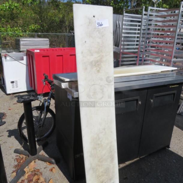 60x12 cutting board, used condition, rectangular shape, visible wear, outdoors Among industry equipment, tagged "346".