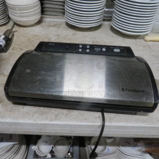 FoodSaver vacuum sealer, stainless steel, minor surface wear, visible control buttons, used condition.