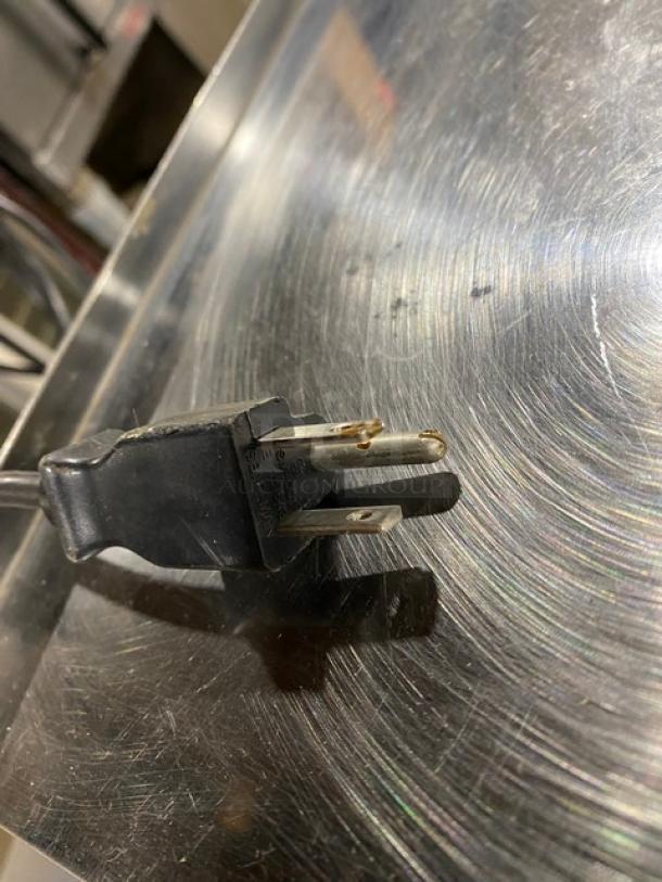 CAS-USA LP-1000 electric scale plug on stainless steel worktop. Features digital price computing and label printer. 120V.