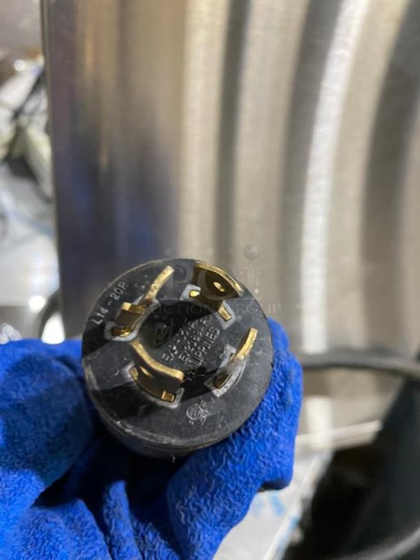 Bunn CWT35 coffee brewer plug shown; black with three brass prongs. Part of the commercial brewing system setup.