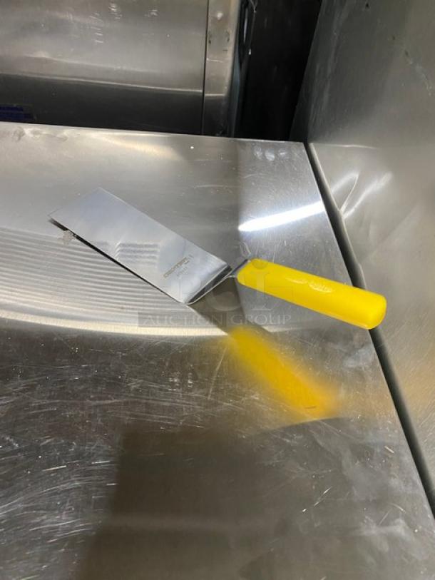 Dexter Russell 8"x3" stainless steel turner, model 31989Y, with yellow grip handle. New condition.