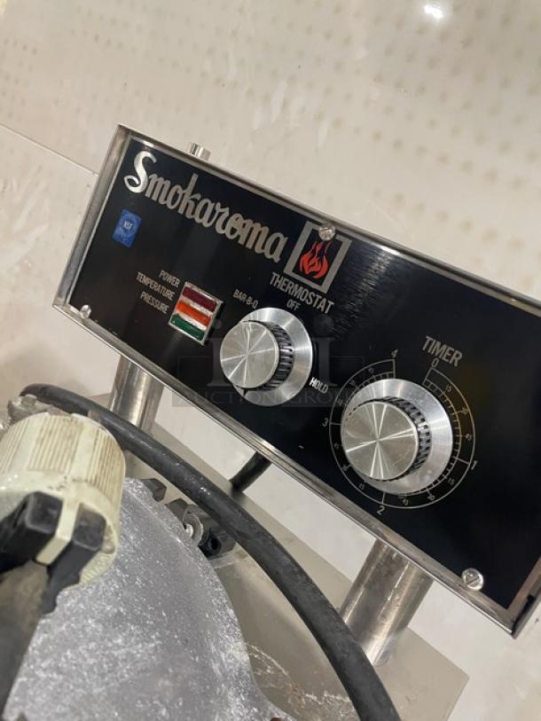 Broaster Smokaroma Series stainless steel electric pressure smoker, featuring control knobs and indicator lights, on legs.