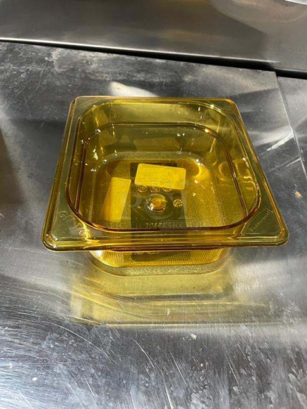 Rubbermaid FG204P00AMBR amber 1/6-size food pan, 2.5" deep, high heat resistant, new condition, on a metal surface.