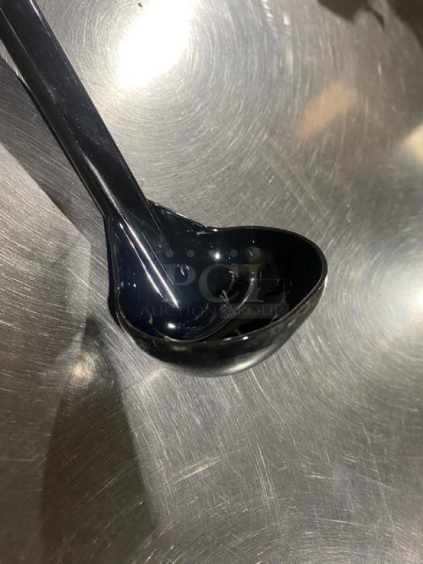 Brand new Carlisle 9.5" lemon vinaigrette style black ladle, model 02955979, on metallic surface.