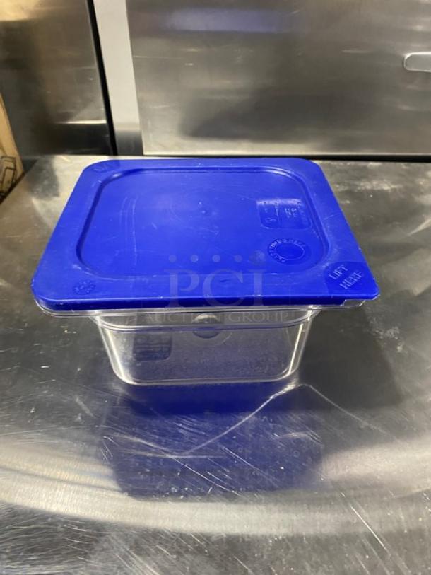 Carlisle clear polycarbonate food storage container with a blue lid, showcasing durable construction and labeled "Lid" on top.