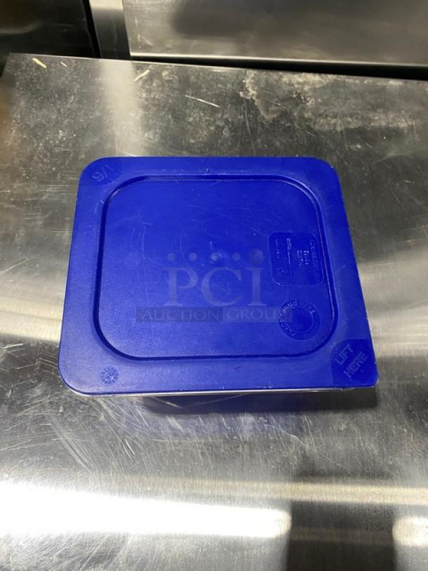 Carlisle clear polycarbonate food storage container with blue lid. Features 6X bid offer and "Lift Here" marking on lid.