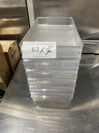 Stackable clear polycarbonate containers, commercial use, pristine condition, set of 7. Tag indicates auction info and quantity.