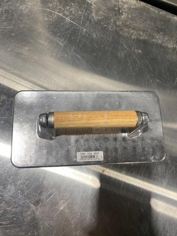 Brand new Vollrath cast aluminum steak weight, waffle-patterned grid bottom, wooden grip handle, model 47709.