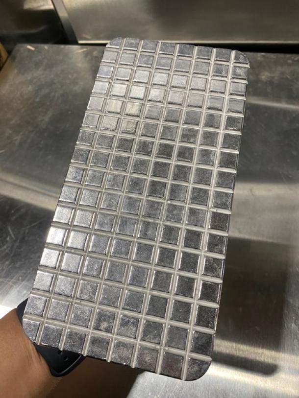 Brand new Vollrath steak weight, model 47709, cast aluminum waffle-patterned grid, wooden grip handle.