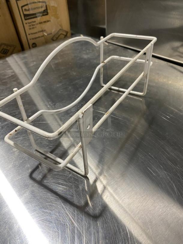 White wired wall-mount glove box holder dispenser, slightly worn, sturdy metal construction, designed for commercial use.