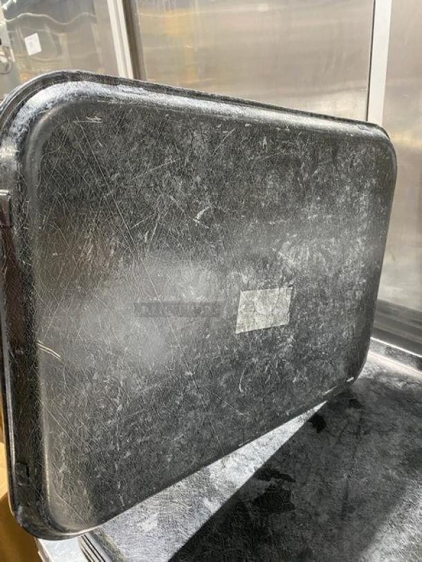 Commercial black rectangular fast food tray, showing signs of wear. Ideal for high-volume serving environments.