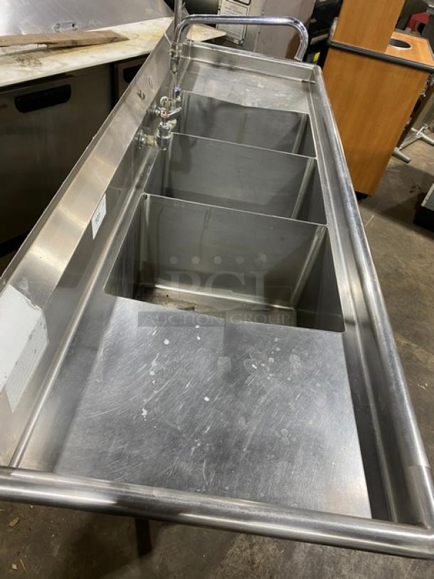 Duke Manufacturing commercial 3-compartment stainless steel sink with left and right drain boards, backsplash, and jet spray faucet.