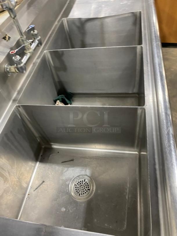 Duke Manufacturing stainless steel 3-compartment sink with left and right drain boards, backsplash, and swing spout faucet.