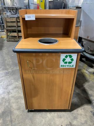 Commercial wooden recycling receptacle with a round waste opening, upper serving tray storage, and recycle symbol.