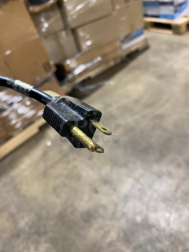 Close-up of a power plug for a Duke Manufacturing countertop soup warmer, model CSW1TAM, on a warehouse floor.