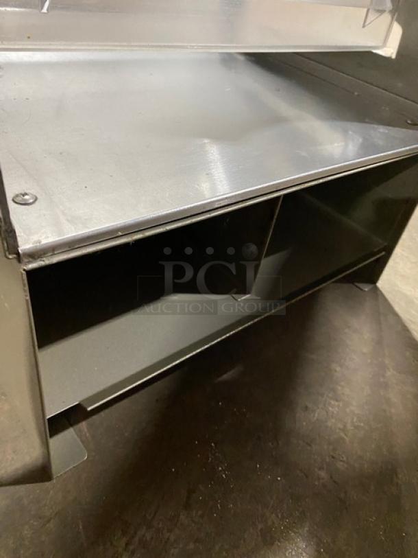 Subway-style multi-tier dessert merchandiser with clear pull-out trays. Features stainless steel construction. Good condition.