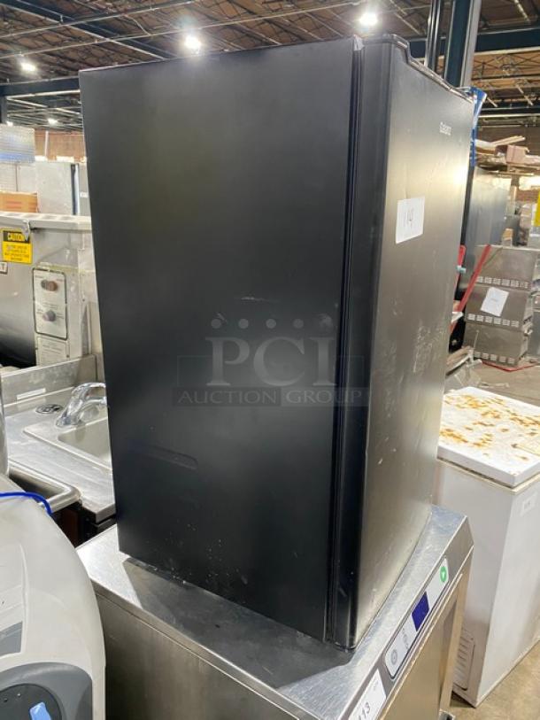 Galanz black mini refrigerator, model GLR33MBKE23. Single door, free-standing. Used condition; minor scratches visible.