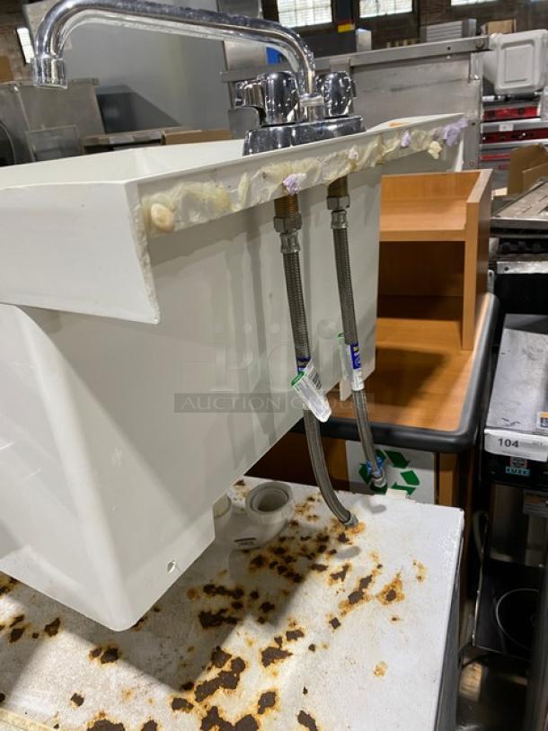 Commercial white single compartment mop service basin with swing spout faucet and legs, visible plumbing, used condition.