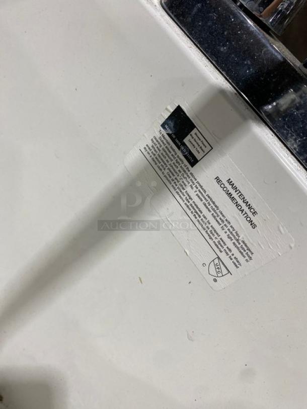 Commercial white single compartment mop service basin with swing spout faucet and legs. Maintenance label visible, good condition.