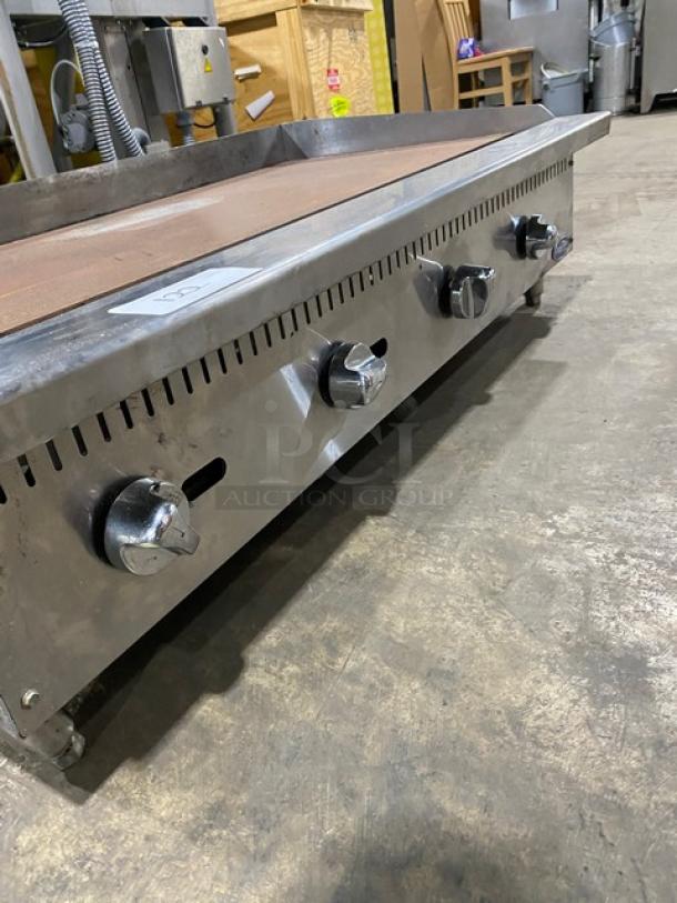 Cook Rite commercial stainless steel countertop griddle with natural gas power, featuring back and side splash, on legs.