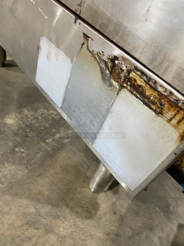 Cook Rite stainless steel natural gas countertop flat griddle with back and side splash on legs, used condition, visible wear.