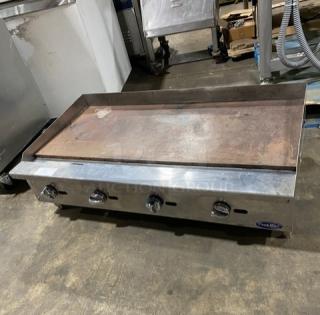 Cook Rite 48" stainless steel flat griddle, natural gas, with back and side splash. Features knobs and sturdy legs.